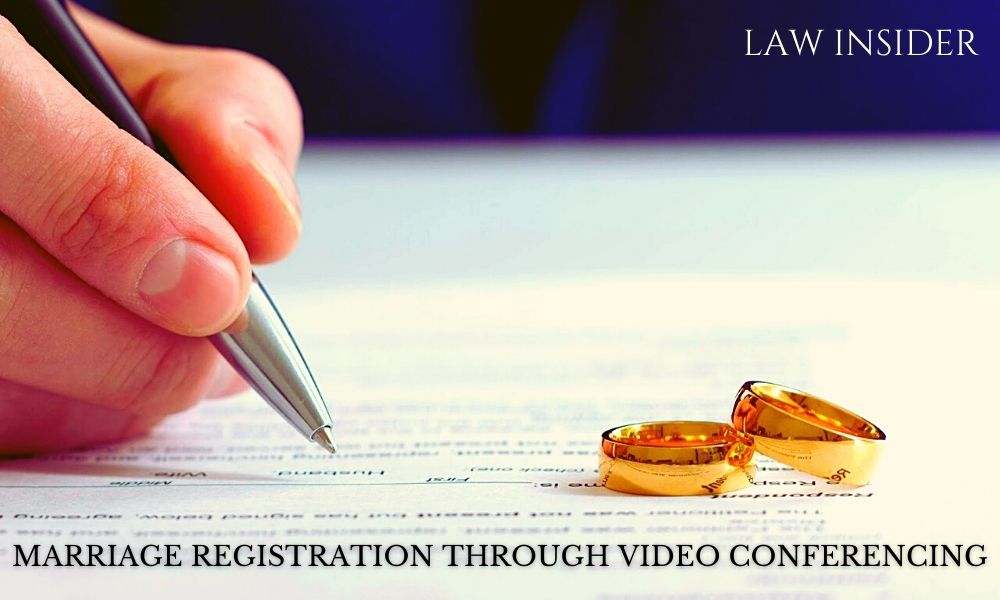 Marriage registration on video call, white form filled by the man with a pen, two golden wedding bands